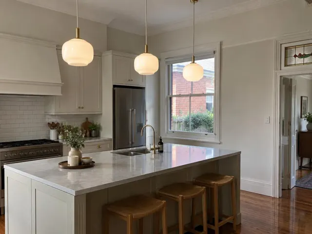Three pendant lights over a kitchen island in a modern home with white cabinets and timber floors in Gordon